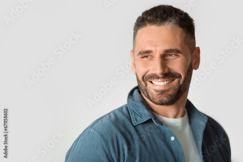 Middle aged guy looking aside over white studio backdrop