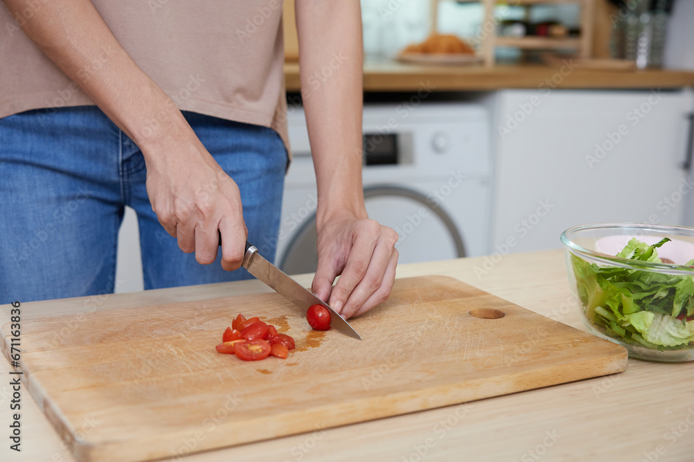 close up young woman hands cutting tomato and cooking salad in the kitchen close up young woman hands cutting tomato and cooking salad in the kitchen