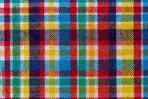 The texture of linen fabric in a large cage of blue, red, yellow and white. Scottish tailoring material. Checkered fabric