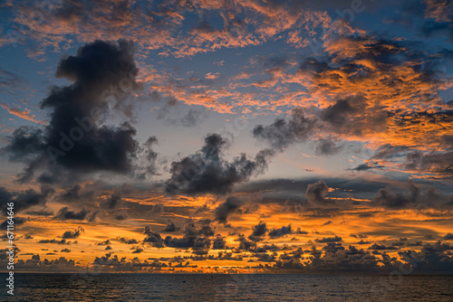 Sunset over the water with clouds against the sunlight on the Andaman Sea, Patong, Phuket, Thailand.