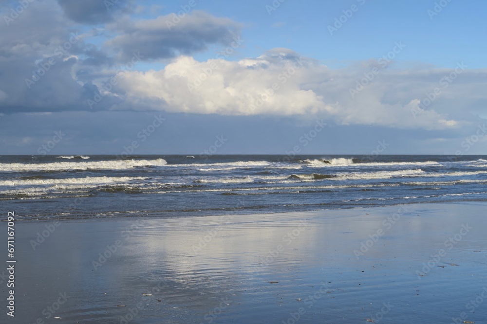 Obraz premium Wellen branden an einem stürmischen Herbsttag an den Strand der Nordseeinsel Schiermonnikoog.