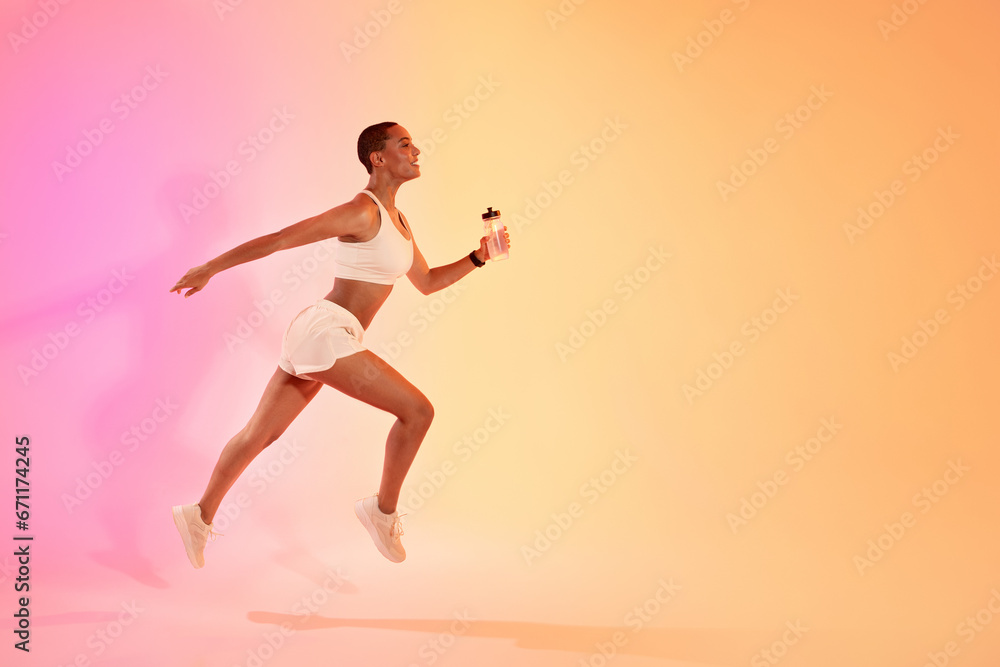 Concentrated young latin lady athlete in sportswear run with bottle of water