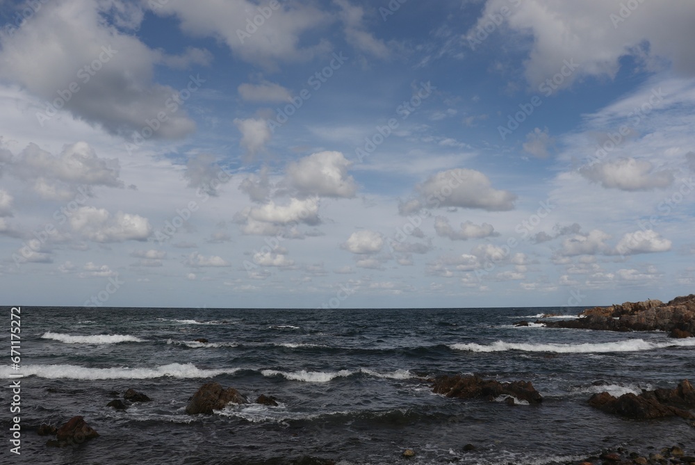 It's a description of the beach in Sokcho, South Korea, with scattered ancient rocks and a very blue sea with rough waves.