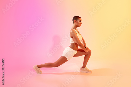 Focused active slim millennial latin woman athlete in sportswear doing lunges for legs