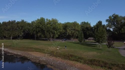 Aerial Footage of Pond in Montana with man walking dogs, Summertime
