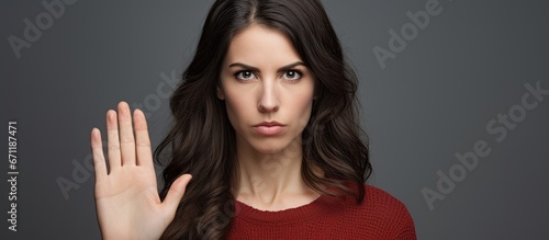 Wallpaper Mural A determined and serious young woman adorned with beauty firmly raises her hand as she gestures to stop and reject the concept Torontodigital.ca