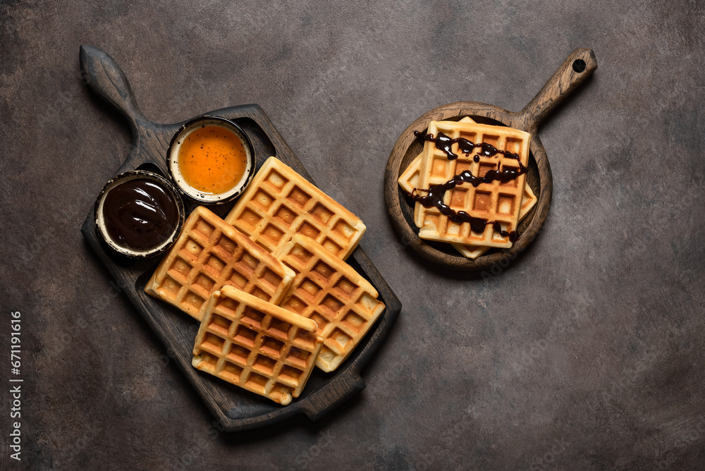 Homemade Belgian waffles with honey and liquid chocolate, dark rustic background. Top view, flat lay Homemade Belgian waffles with honey and liquid chocolate, dark rustic background. Top view, flat lay