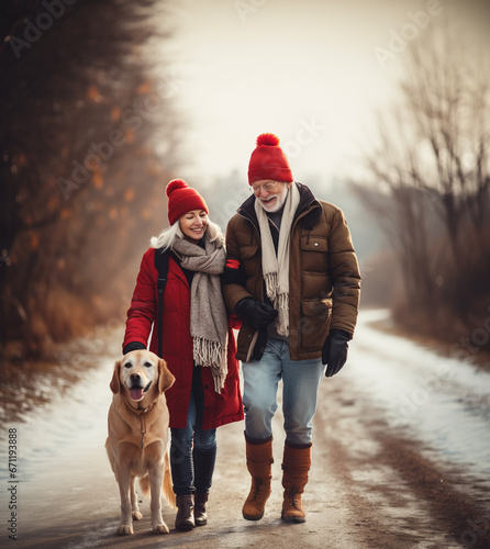 Loving family walking with their golden retriever dog on a snowy country road. Smiling woman and older man wearing red Christmas hats, taking a walk on a calm winter day. photo