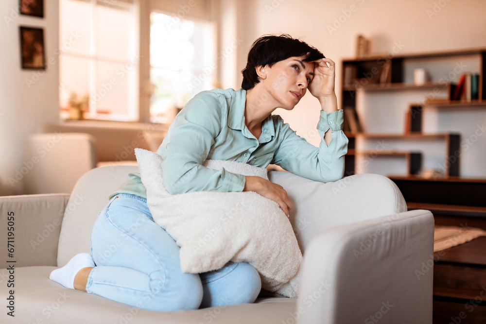 Middle aged woman displaying signs of fatigue and depression indoor