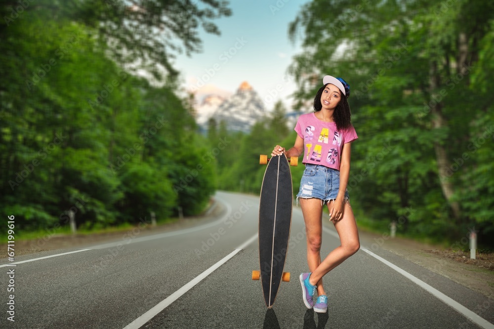 Fototapeta premium Portrait of carefree young girl riding skateboard