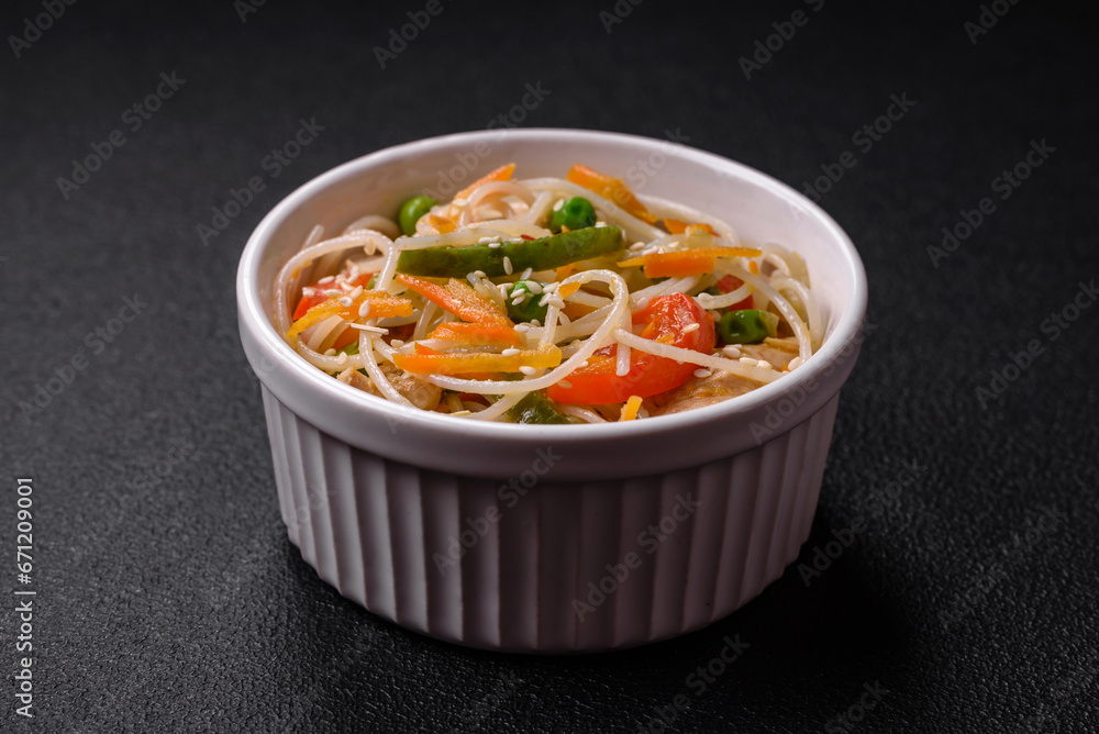 Tasty dish of Asian cuisine with rice noodles, chicken, asparagus, pepper, sesame seeds Tasty dish of Asian cuisine with rice noodles, chicken, asparagus, pepper, sesame seeds