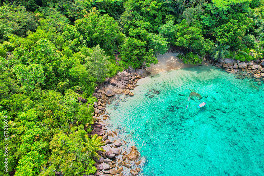 Drone shot of Anse Major beach, couple snorkeling, near docked boat, Mahe, Seychelles Drone shot of Anse Major beach, couple snorkeling, near docked boat, Mahe, Seychelles