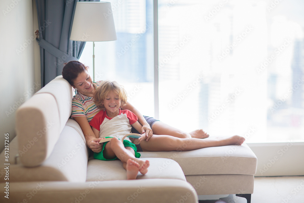 Child and mother read a book in sunny room Child and mother read a book in sunny room