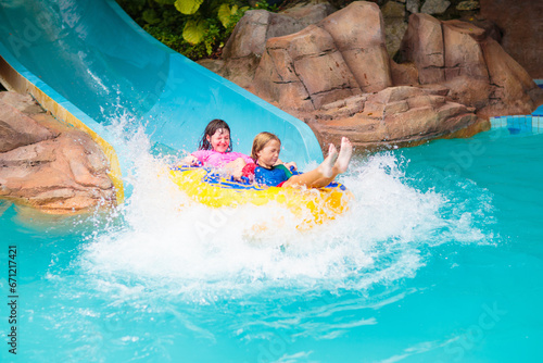 Kids on water slide. Family in aqua theme park. © famveldman