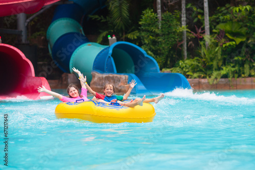 Kids on water slide. Family in aqua theme park.