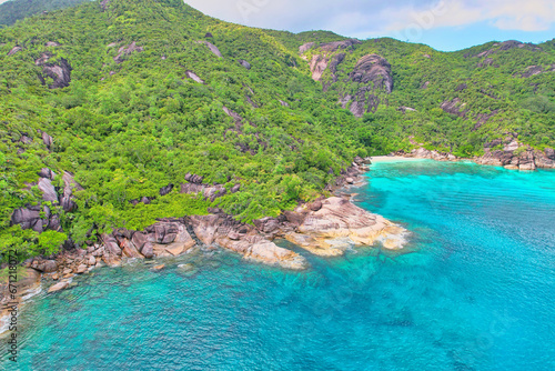 Drone shot of Anse du riz, rice beach beach, transparent sea, lush forest and granite stones, Mahe, Seychelles 1