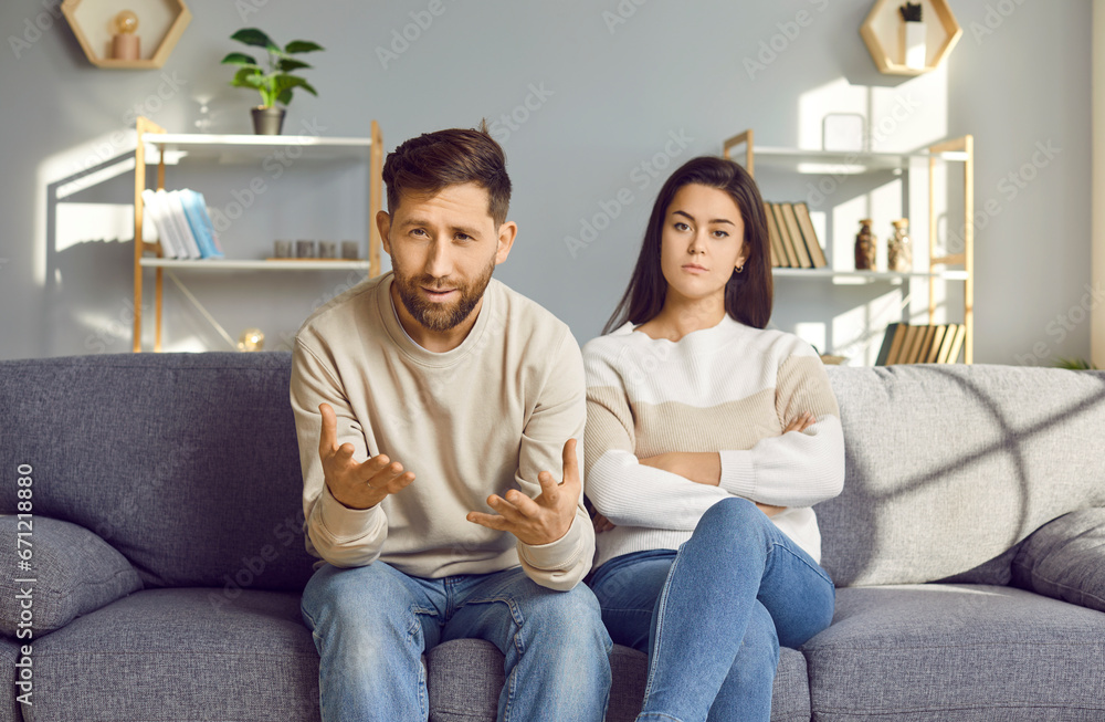 Married family couple talking about relationship problems. Frustrated man and angry woman sitting on couch in front of camera, having remote online therapy session and asking psychologist for advice