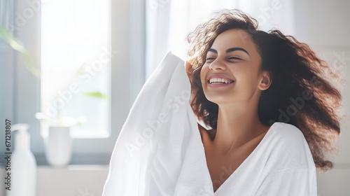 portrait of a smiling, relaxed woman in bathroom with a white towel photo