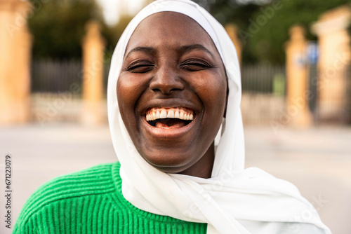 Portrait of beautiful african muslim woman in hijab smiling at camera outside