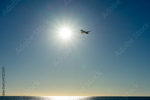 Airplane landing at sunrise over Mediterranean Sea, Costa del Sol in Malaga, Spain