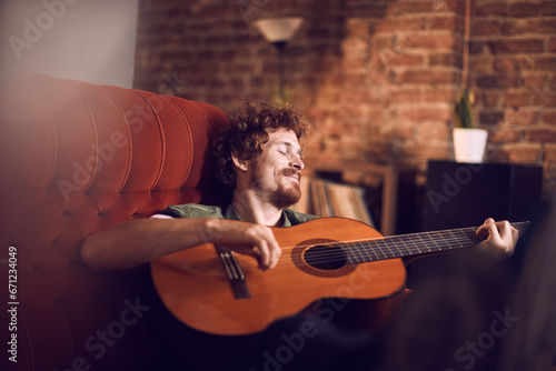 Musician lost in the melody of his guitar at a cozy bar photo