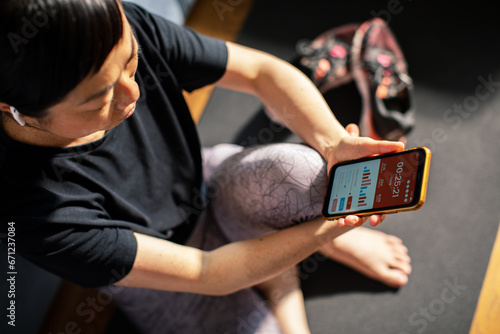 Woman checking her fitness progress on a smartphone photo