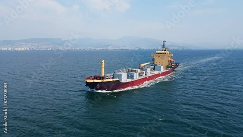 Aerial view of a heavy loaded cement cargo vessel in transit from industrial port