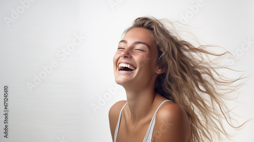 Happy young blonde woman in her 20s smiling and laughing. Isolated on white background.
