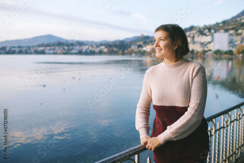 Outdoor portrait of beautiful young woman relaxing by mountain lake, cold weather