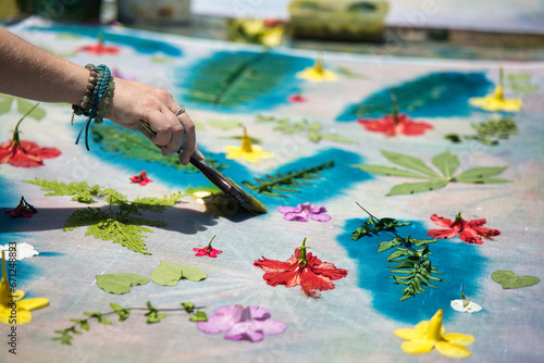White skin woman, painting over leaves with cloth printing ink at workshop for her pareo making, Mahe Seychelles 5