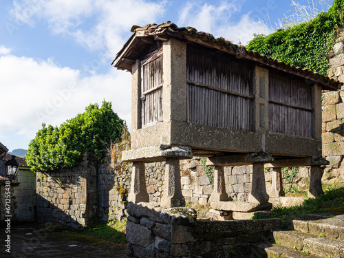 Tableau sur toile Vista de un granero típico gallego llamado hórreo sobre columnas, de madera aislado del suelo en Allaritz, Galicia, verano de 2021, viajando por España