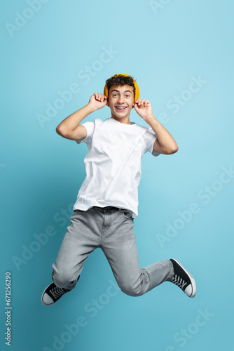 Portrait of smiling teenage boy wearing stylish casual clothes, yellow hat, dental braces