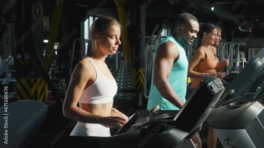 Men and women athletes run on treadmill working out at gym Men and women athletes run on treadmill working out at gym