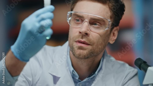 Sad laboratory researcher analyzing test tube dissatisfied experiment close up.