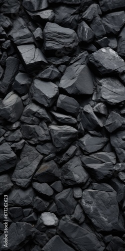 A pile of black rocks is displayed in this image. This versatile picture can be used to depict nature, landscapes, geology, or even abstract concepts