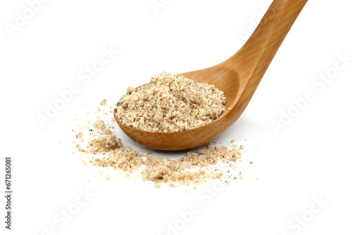 Shelled and ground Ground, milled, crushed almond nuts in a  wooden spoon isolated on white. Edible, dried, brown seeds of Prunus dulcis. Ingredient in marzipan, nougat, cookies.