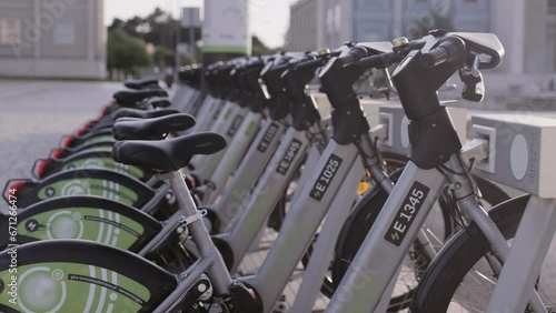 Many public bicycles for rent at bike station on street of Lisbon. Popular rental ecological transport for traveling around city for tourists and citizens. Portugal, Lisboa. July 16, 2022.