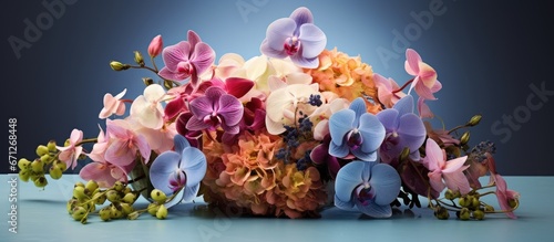 A mixture of vibrant hydrangeas and orchids arranged together enhances the appearance of a table during a meal