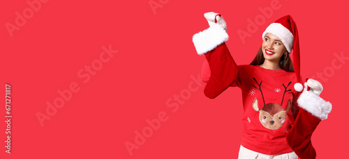 Beautiful young woman with Christmas socks on red background with space for text