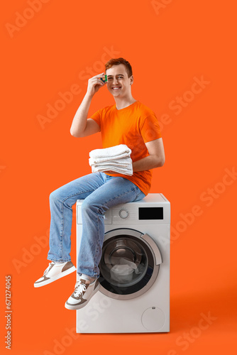 Young man sitting on washin...