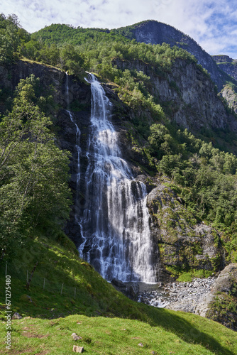 Landscape picture of beautiful Norwegian Brekkefossen waterfall. Popular touristic attraction and hard hiking route with lots of big stone stairs in city of Flam in Aurland region of Norway.