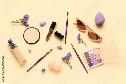 Composition with makeup products, beautiful gypsophila flowers and sunglasses on beige background