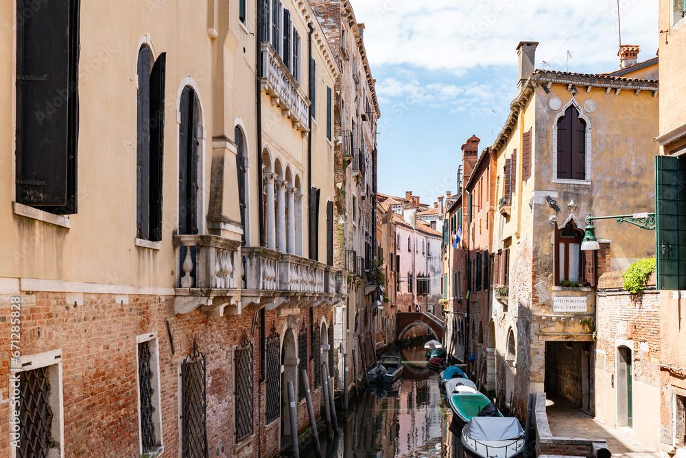 Scenic canal with bridge and old buildings with potted plants in Venice, Italy