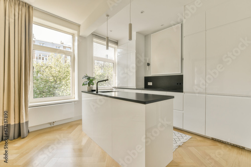 Kitchen with white cabinets next to bright window photo