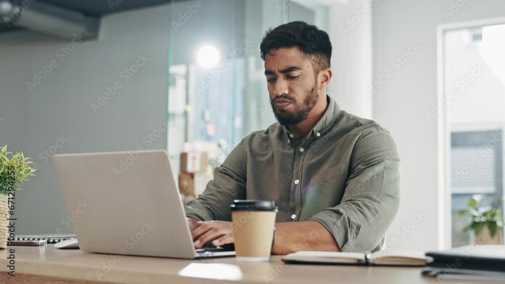 Laptop, coffee and frustrated man typing in office for online company, startup career or job in project management planning. Indian person or employee walking to his desk and working on computer Laptop, coffee and frustrated man typing in office for online company, startup career or job in project management planning. Indian person or employee walking to his desk and working on computer