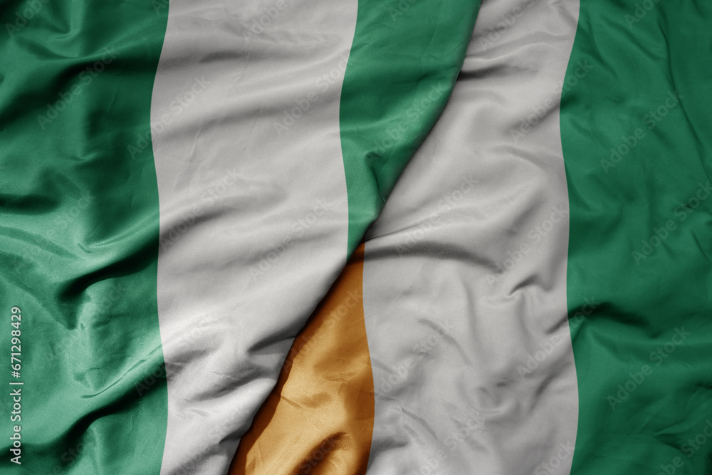 Obraz premium big waving national colorful flag of nigeria and national flag of cote divoire .