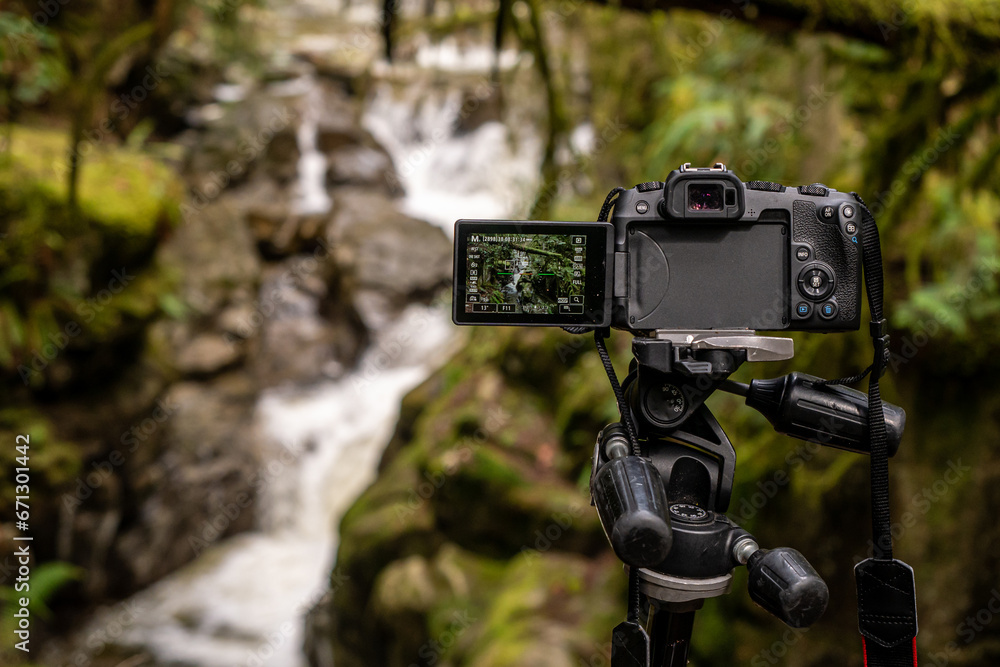 camera being used to photograph a waterfall in the forests of Canada camera being used to photograph a waterfall in the forests of Canada
