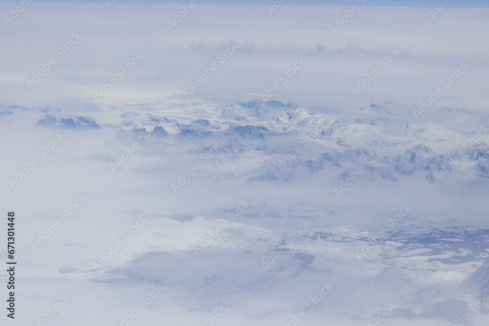 Beautiful high snow Greenland mountain peak landscape in clouds