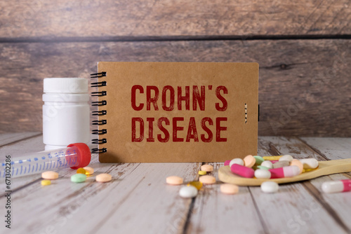 Paper with CROHN'S DISEASE on the office desk, stethoscope and pills, top view photo