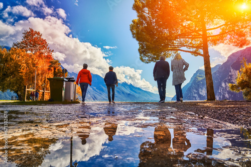 People admiring Lake Garda in autumn time,Garda lake surrounded by mountains, Trentino Alto Adige region, Lago di garda, italy photo